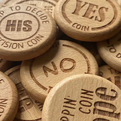 All variants of the Ultimate Decision Maker Coin shown together, each with unique, finely detailed engravings on smooth, solid wood