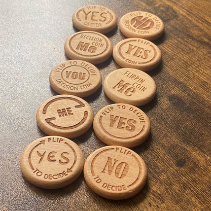 An overhead shot of the Ultimate Decision Maker Coin collection, featuring various engraved designs on solid wood
