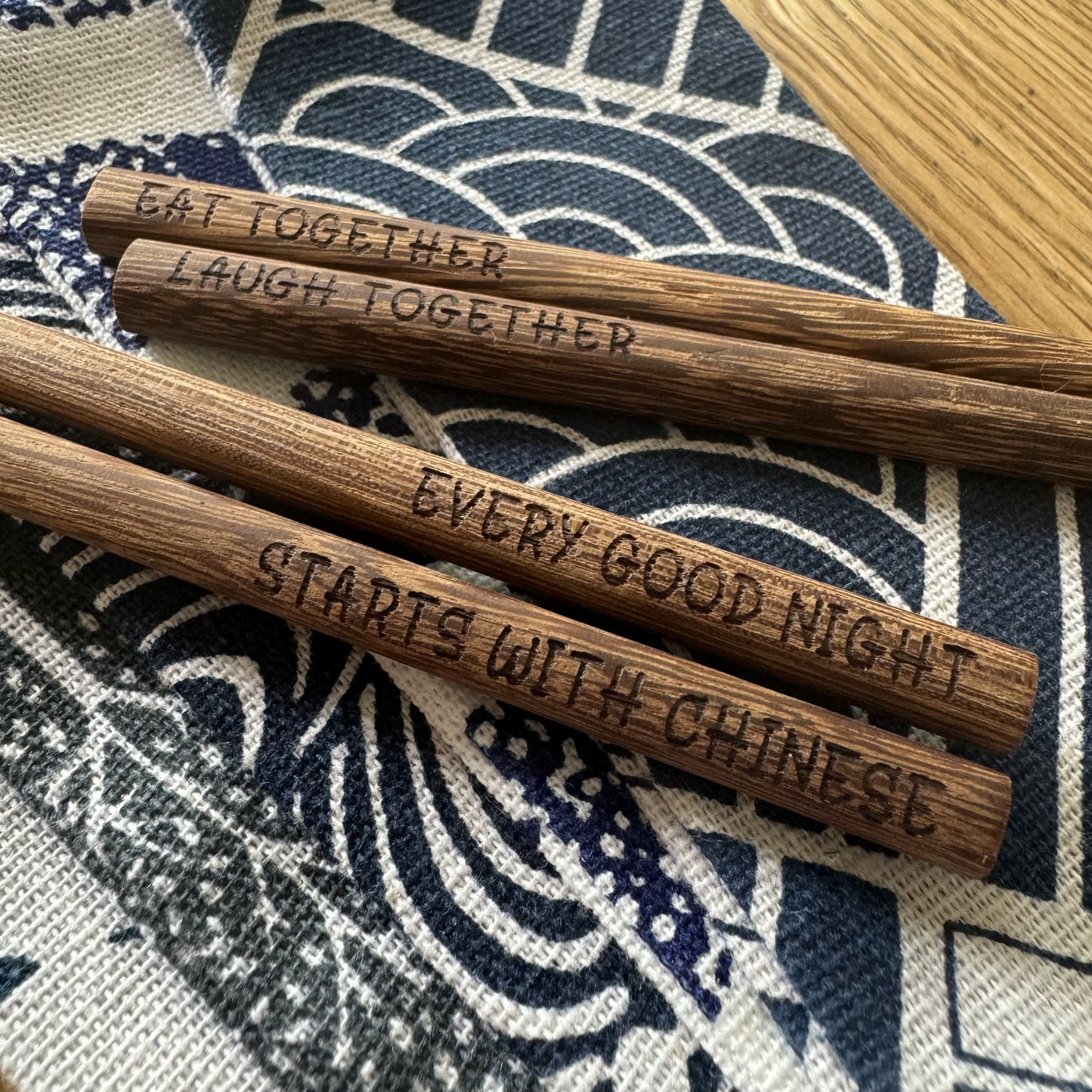 Two wenge chopstick pairs resting on soft pouches.