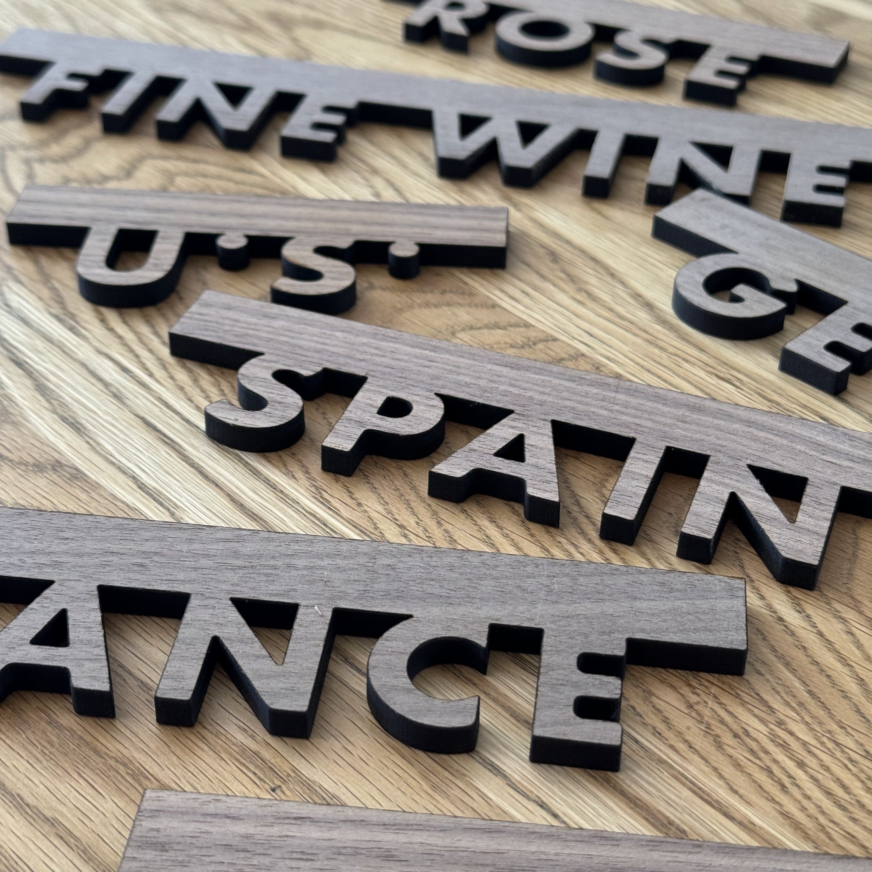 Walnut wood wineshop signage engraved with country name in clean, modern style