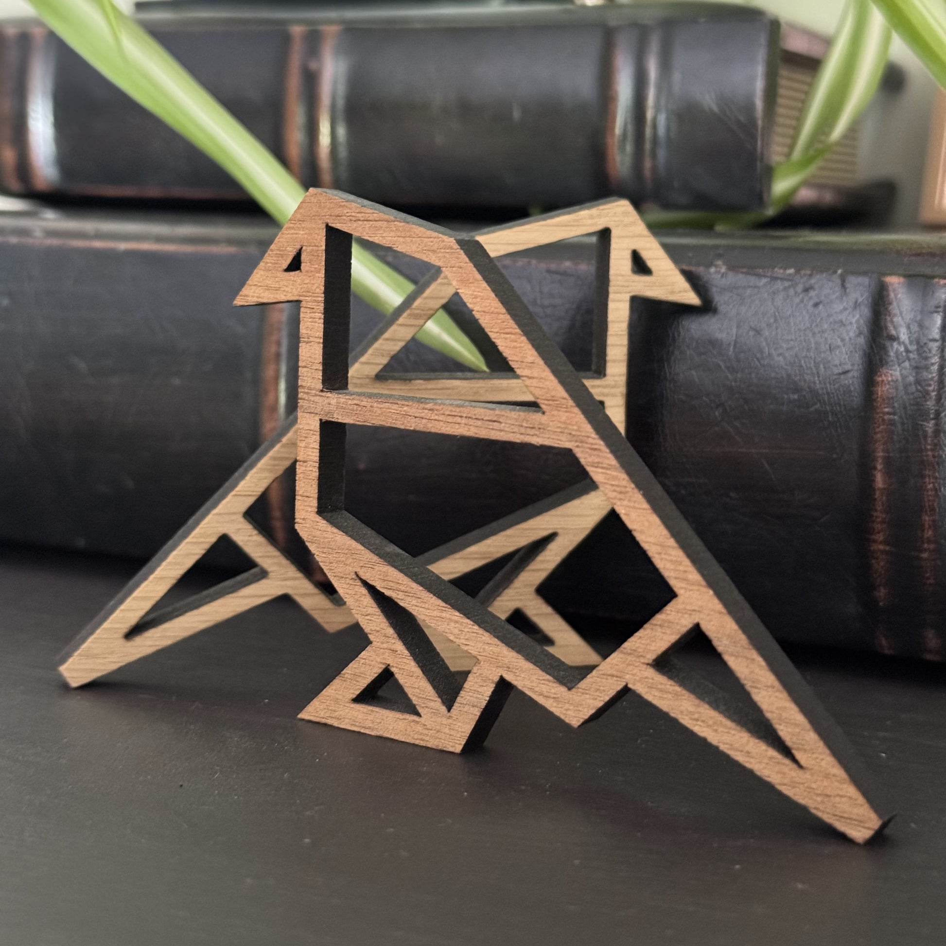 Origami-style wooden bird pair displayed on a shelf, perched on a stack of books for modern decor