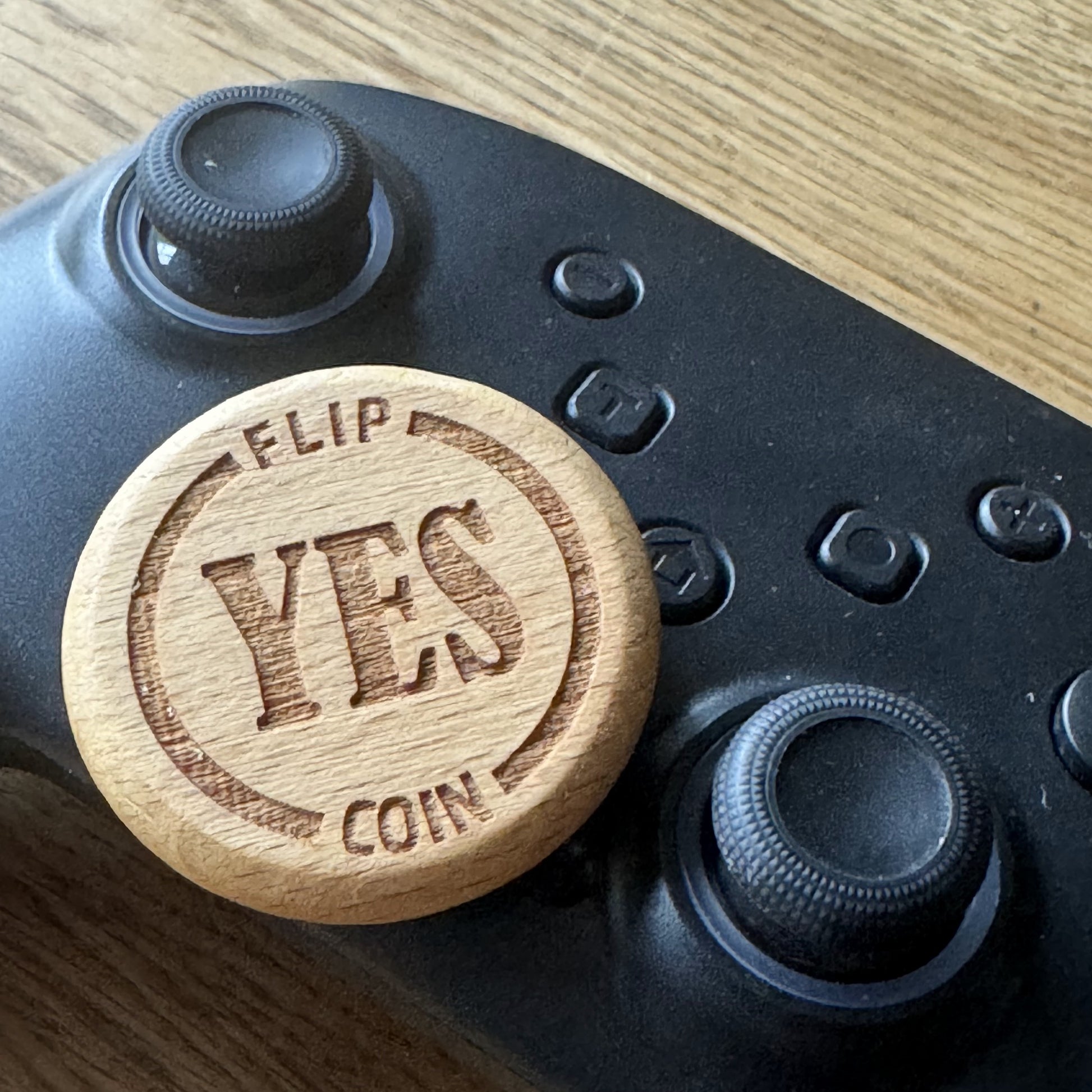 Yes No Ultimate Flip Coin resting on a games controller – fun gaming decision maker